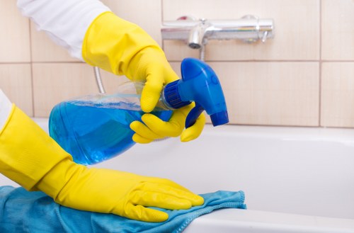 Cleaner tidying a London office kitchen and communal area