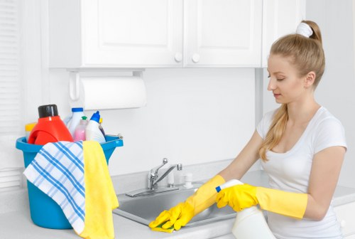Domestic cleaner tidying a modern London kitchen