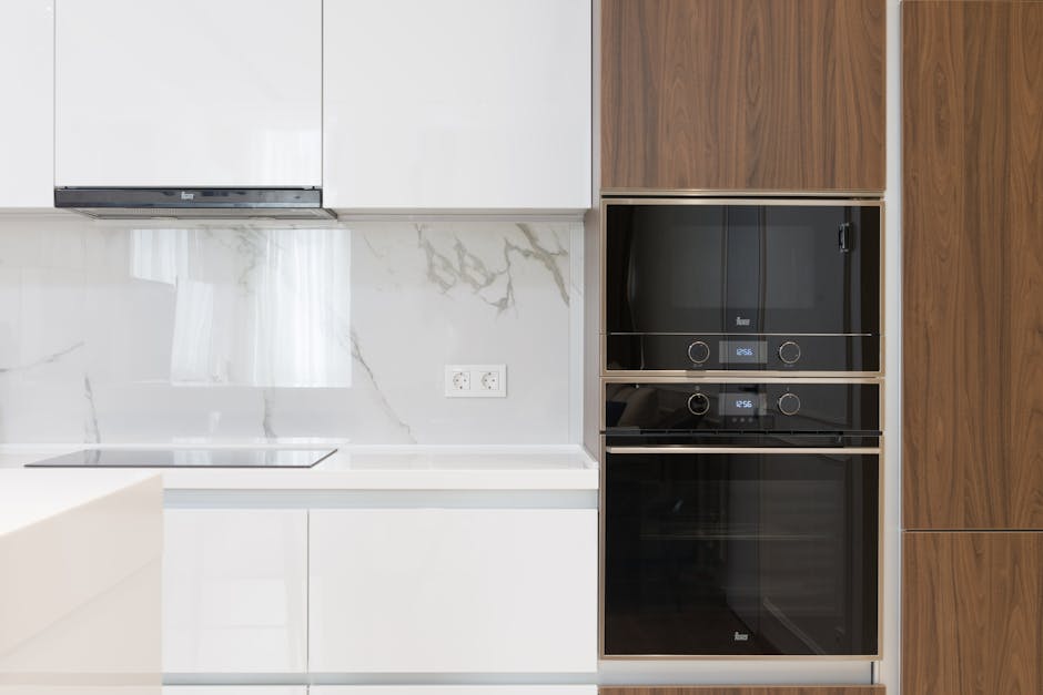 Close-up image of a modern stainless steel oven in a kitchen setting, emphasizing surface cleaning and sanitisation. The oven's control panel with buttons and a display is visible, with the surface ap