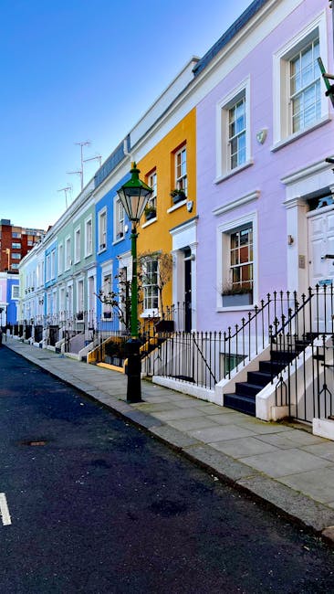 Photograph of a row of white Victorian-style residential buildings in Notting Hill Gate London, with detailed architectural features and multiple windows. A tall palm tree and other greenery, includin